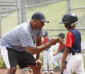 Coach Bumping Fists With Little League Batter